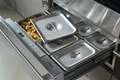 A Wolf WWD3050 30-inch Warming Drawer open showcasing the graphical user interface and multiple pans with different food.