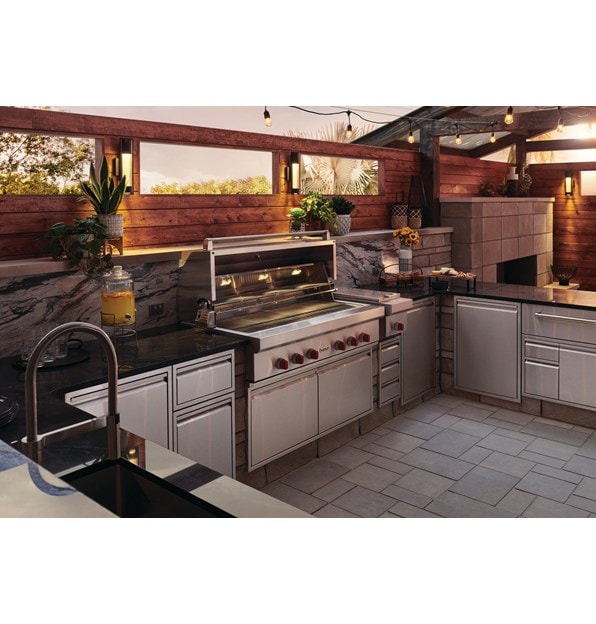 The Wolf 54" Outdoor Gas Grill (OG54) shown blending seamlessly into a rich modern outdoor kitchen design offering pro quality amenities.