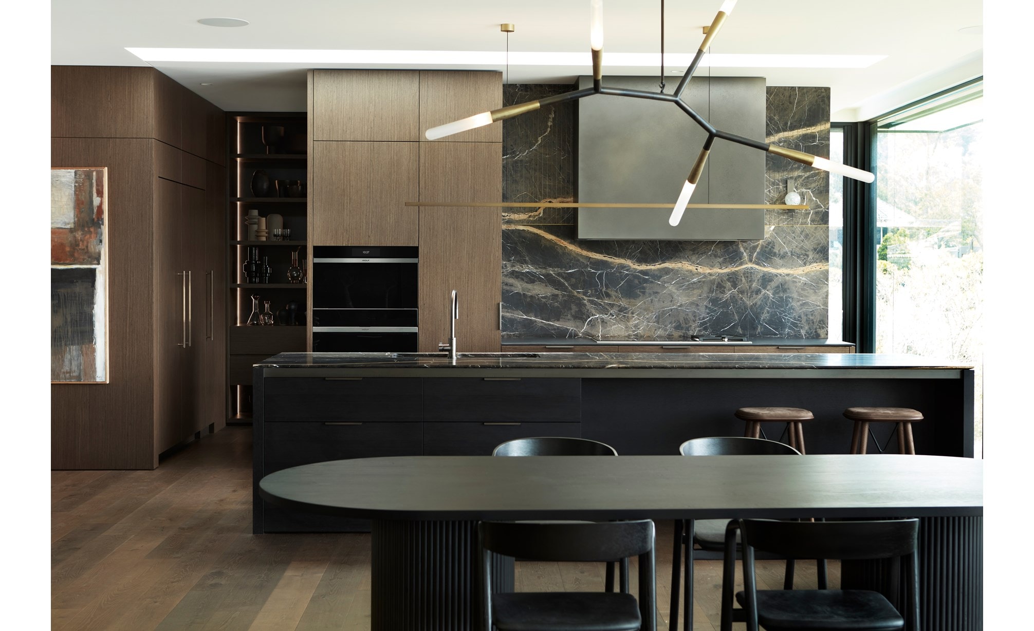 A sleek, dark-themed kitchen featuring Sub-Zero and Wolf products