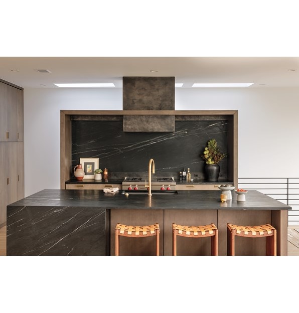 The Wolf 36 Inch Sealed 4 Burner Rangetop and Infrared Griddle installed in a custom wood framed alcove featuring dark marble backsplash with matching kitchen island