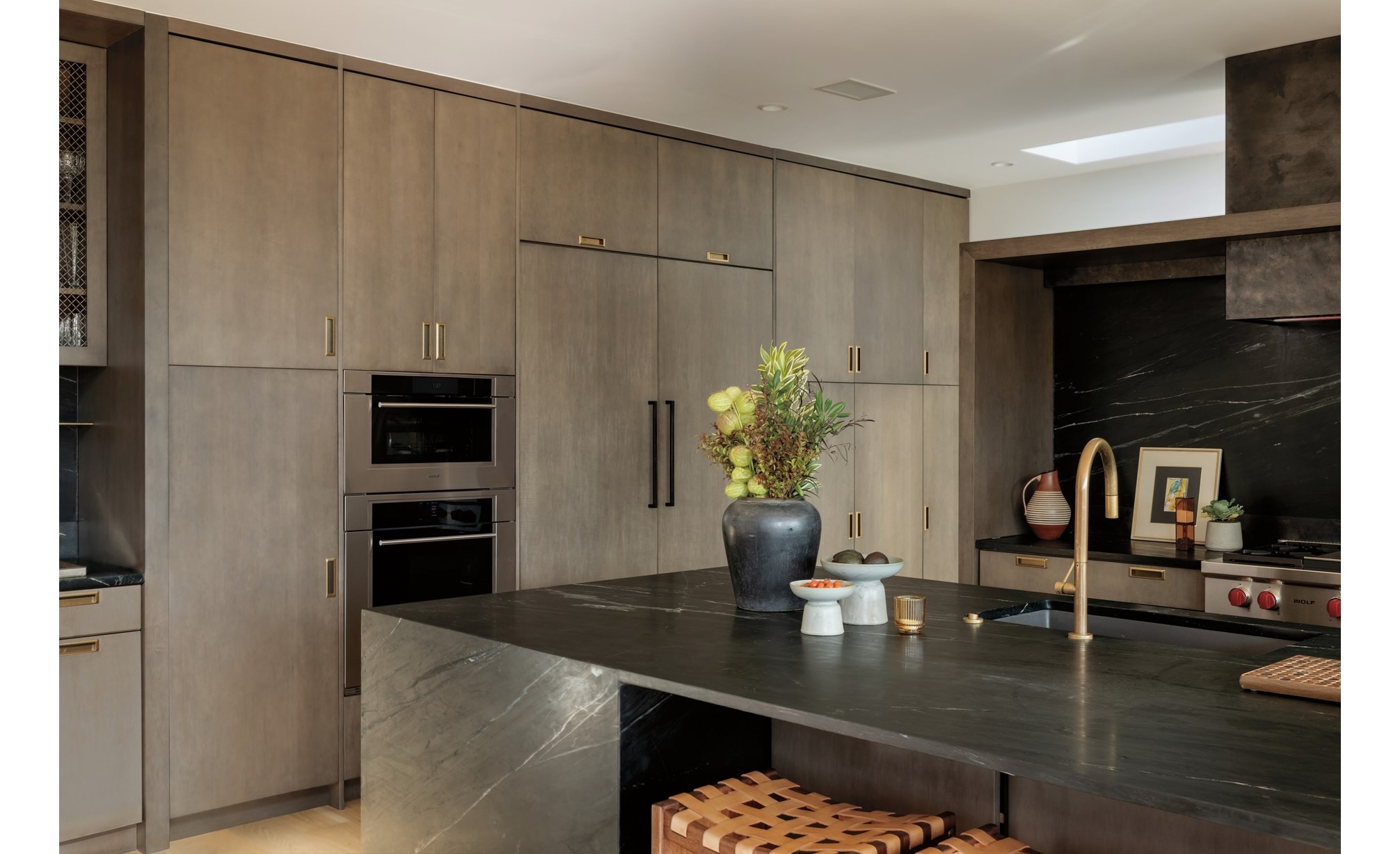 Wolf 24 Inch E Series Transitional Coffee System featured in a luxury coffee bar area with leather swing back chairs