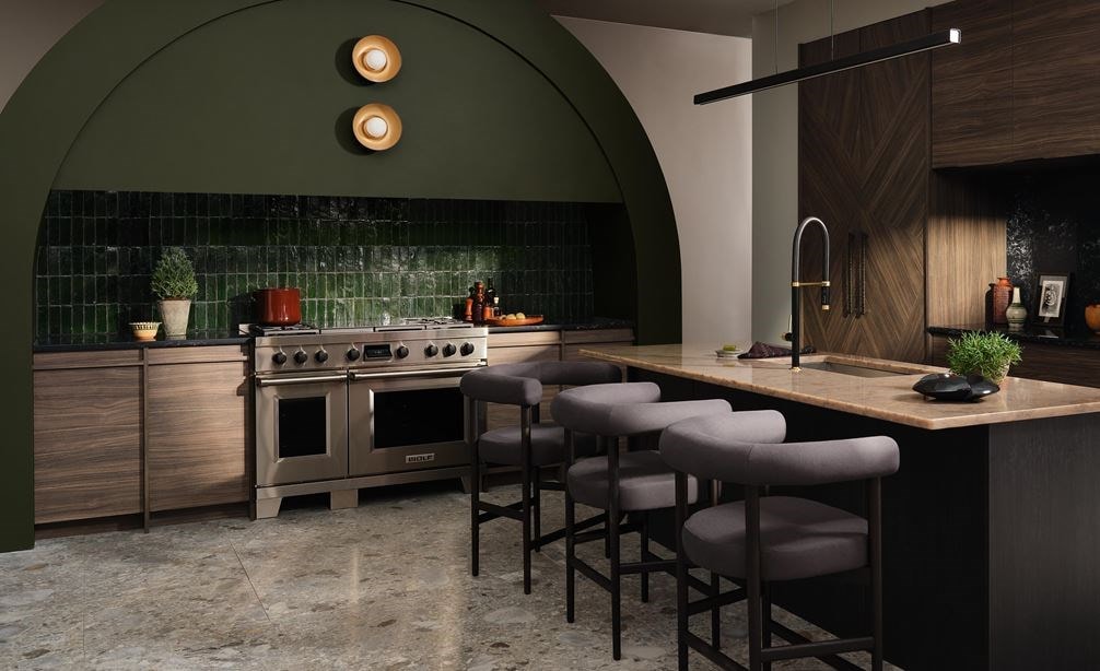 Wolf 24 Inch E Series Transitional Coffee System shown centered in a large forest green arched kitchen design with custom racing green backsplash and custom handleless wood cabinetry