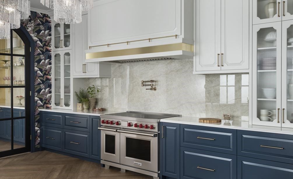 Wolf Professional Induction Range shown in an elegantly appointed modern kitchen featuring tall arched glass upper kitchen cabinets with dark slate blue lower cabinetry.