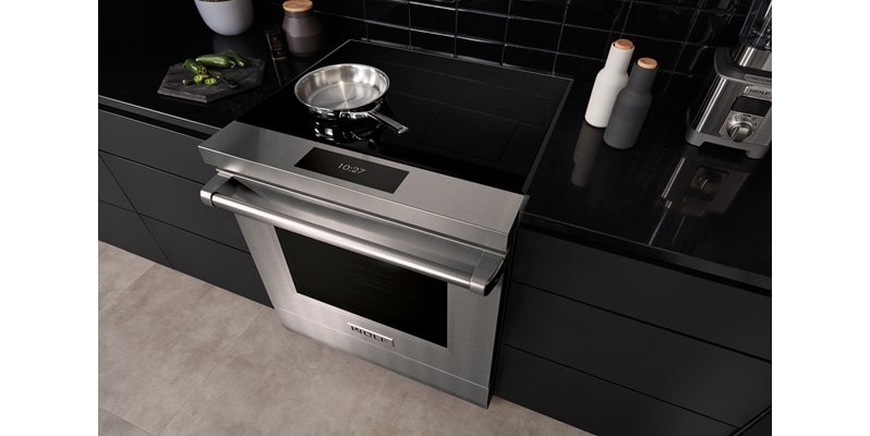 Wolf 36-inch Contemporary Induction Cooktop (CI36560T) featuring sleek black glass surface installed flush in a modern Mediterranean kitchen design.