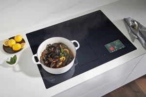 Wolf Convection Steam Oven with temperature probe shown in a minimal European kitchen design featuring clean white cabinetry.