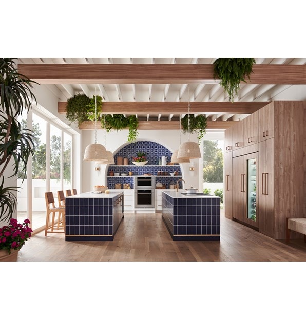 Wolf M Series Transitional Convection Steam Oven (CSO3050TM/S/T) shown in a bright and open Mediterranean kitchen design featuring blue mosaic tile backsplash, white open shelves, pendant lights and gold cabinet handles