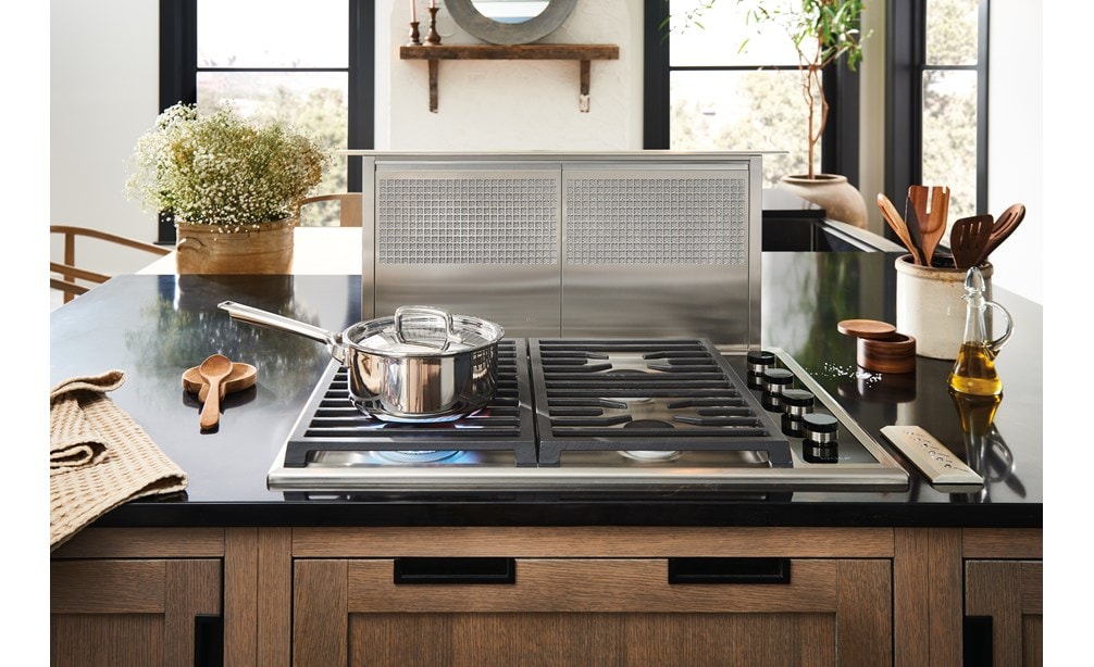 Wolf 30-inch gas cooktop with downdraft shown in a cottage kitchen design featuring warm wood tone cabinets.