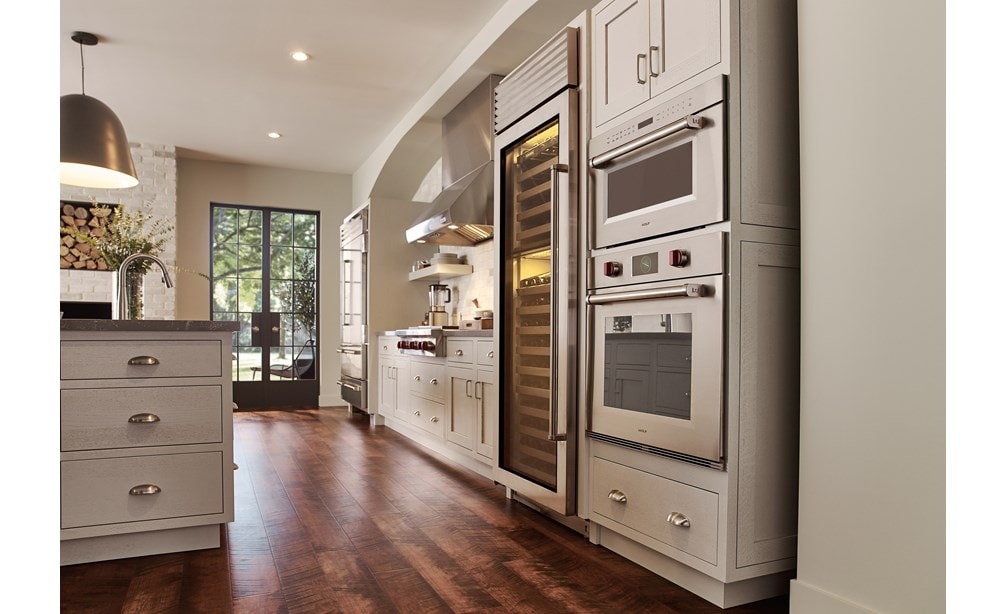 Wolf 30" M series Professional Drop-Down Door Microwave Oven (MDD30PM/S/PH) displayed in a classic medium tone wood floor kitchen design