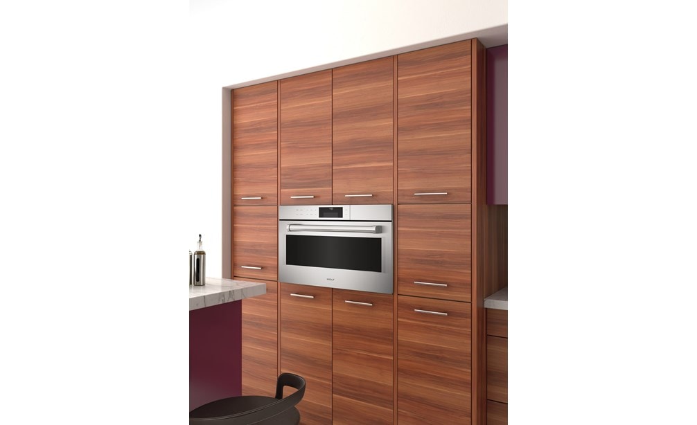The Wolf 30" E Series Professional Convection Steam Oven (CSO30PE/S/PH) shown elevated and framed in a sophisticated cabinet style 