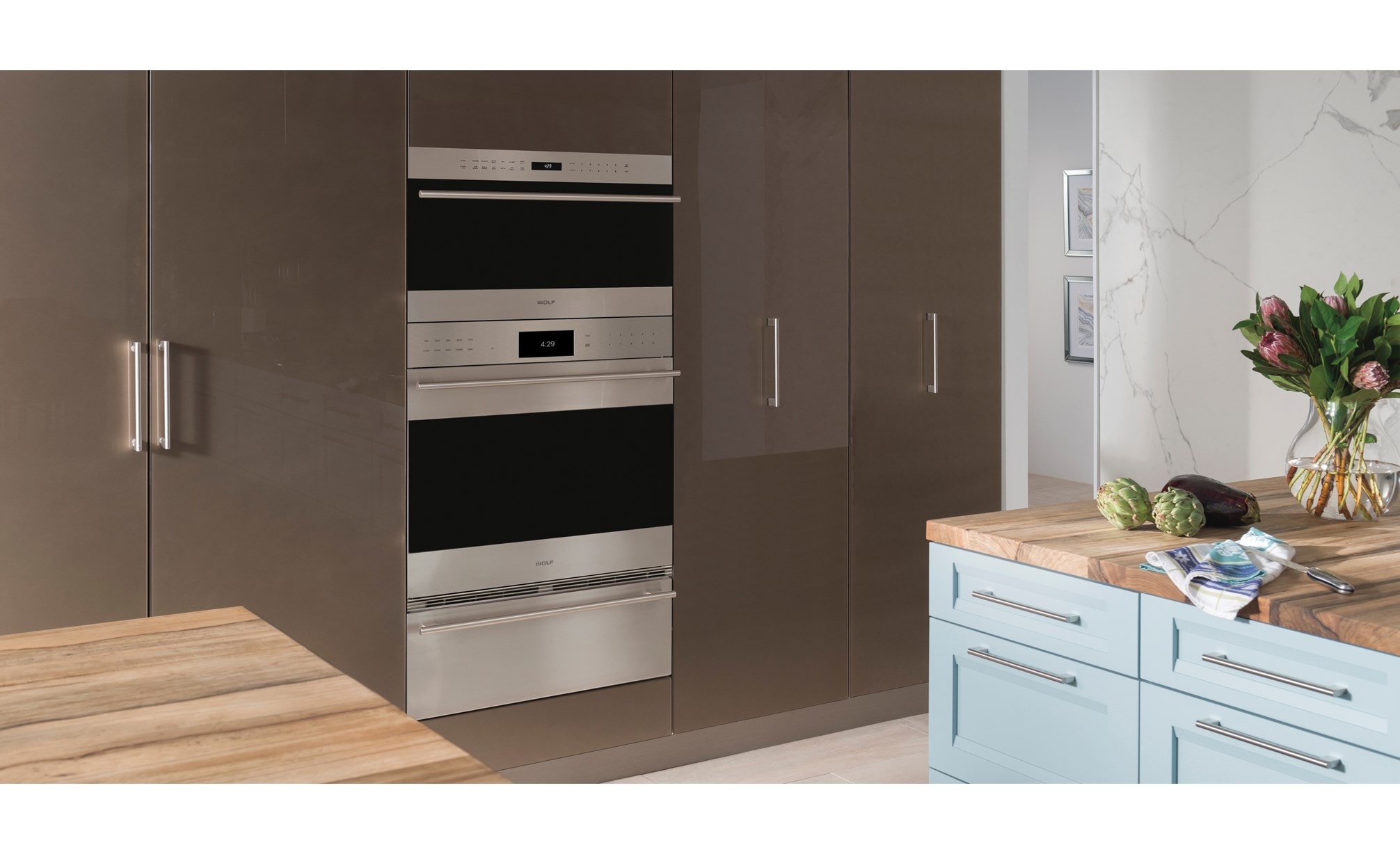 The Wolf 30" E series Transitional Drop-Down Door Microwave Oven (MDD30TE/S/TH) shown set flush in smooth floor to ceiling cabinetry