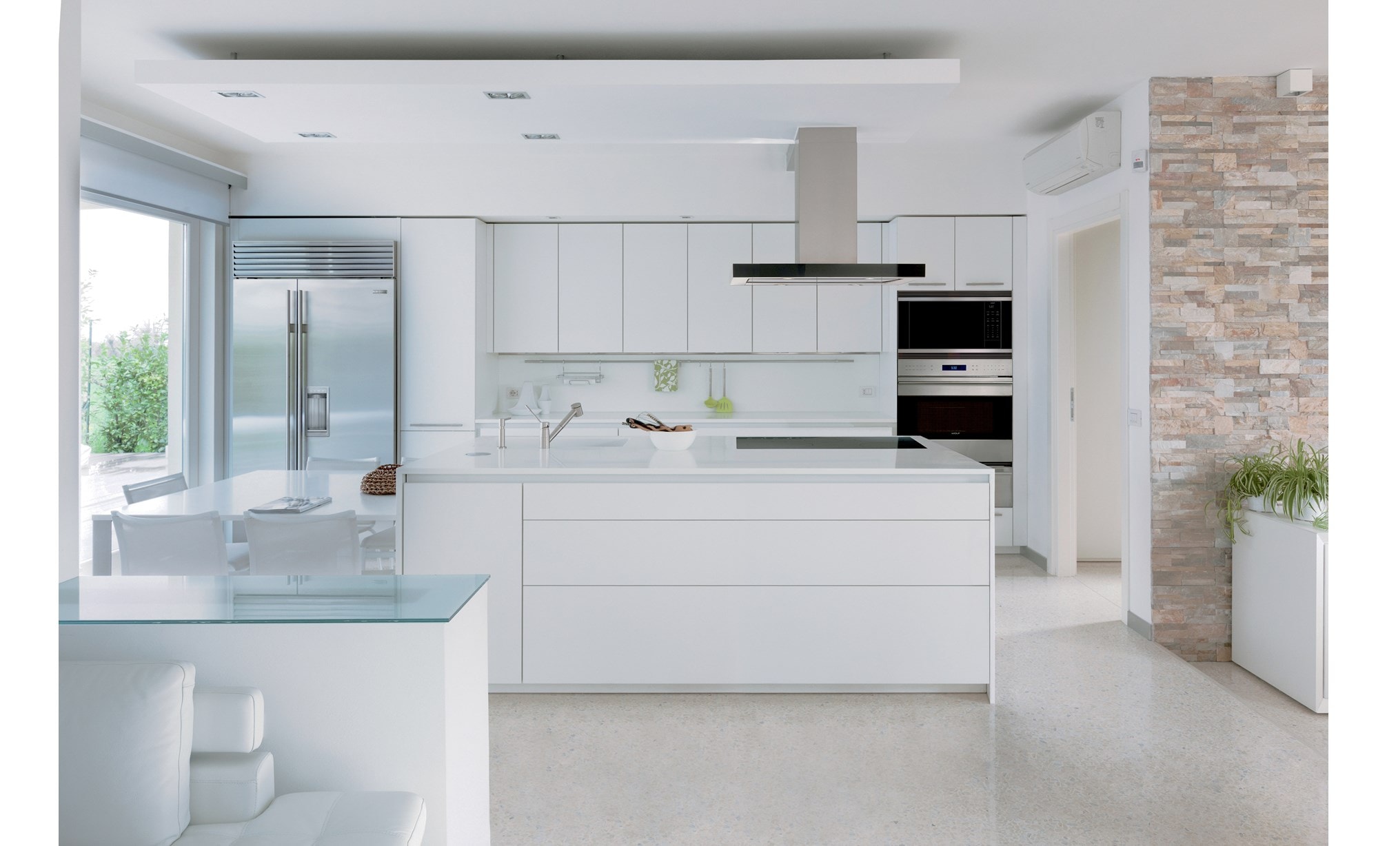 The Wolf 30" E Series Transitional Classic Single Oven (SO30TE/S/TH) shown with 42" Cooktop Island Hood (VI42B) set in sleek cabintery.