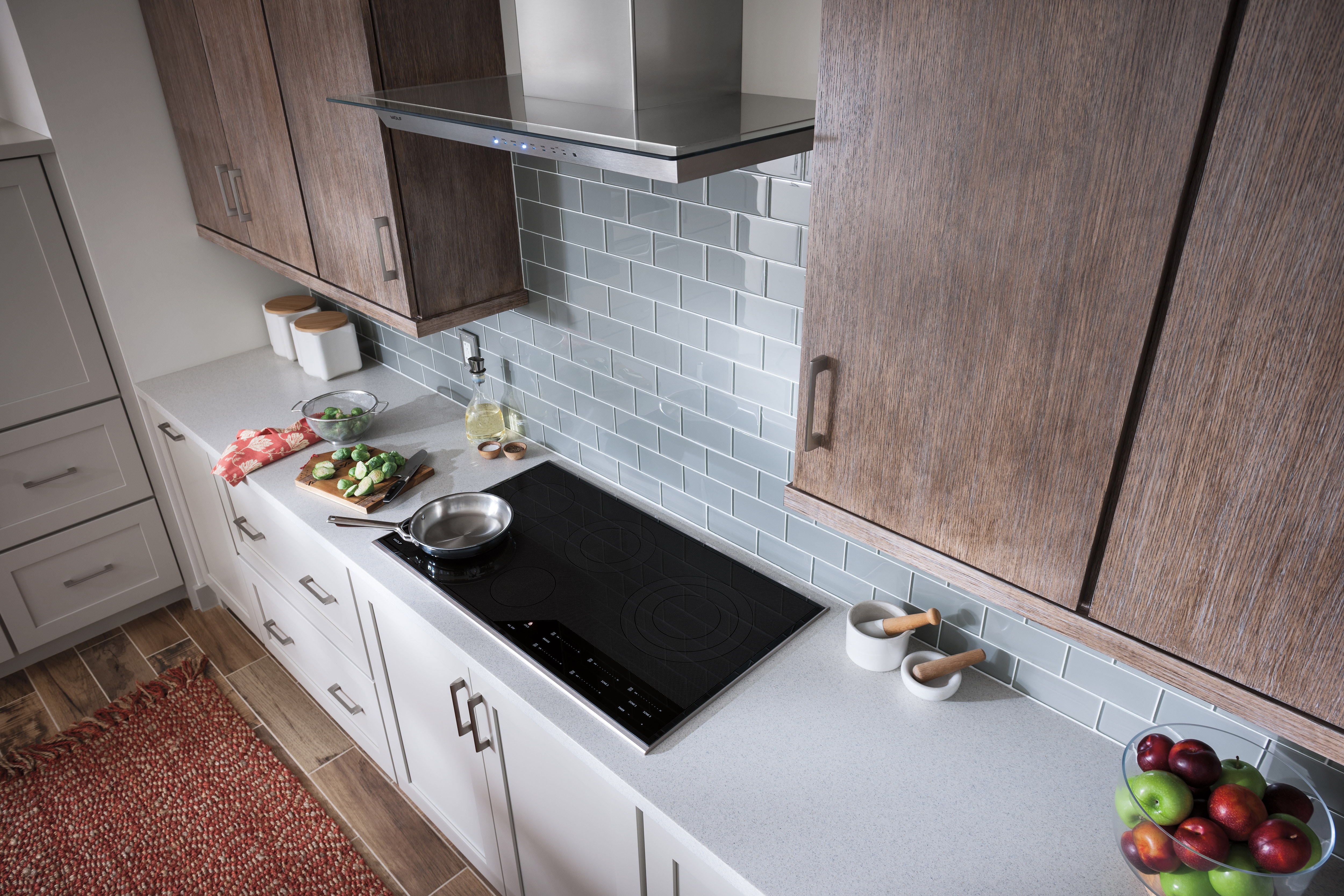 The Wolf 36" Cooktop Wall Hood - Glass (VW36G) featured in a cozy kitchen design with warm wood cabinets and tile backsplash