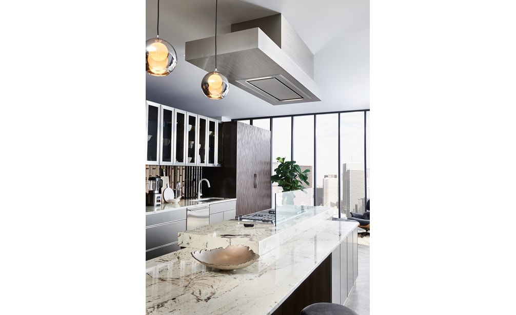 The 48" Ceiling Mounted Hood - Stainless Steel (VC48S) shown adding polish and luxury above large rich swirl granite kitchen countertop